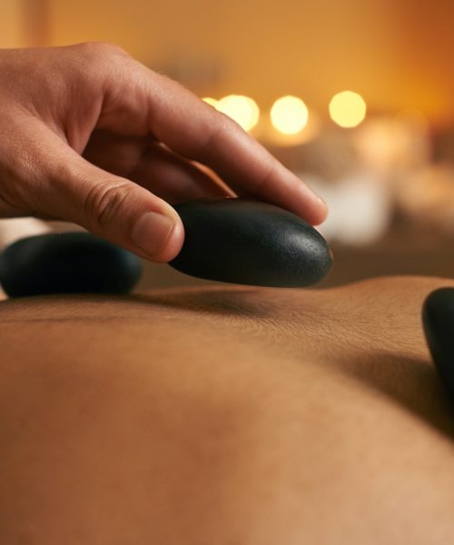 Using alternative therapy. A young woman receiving hot stone therapy at the spa.
